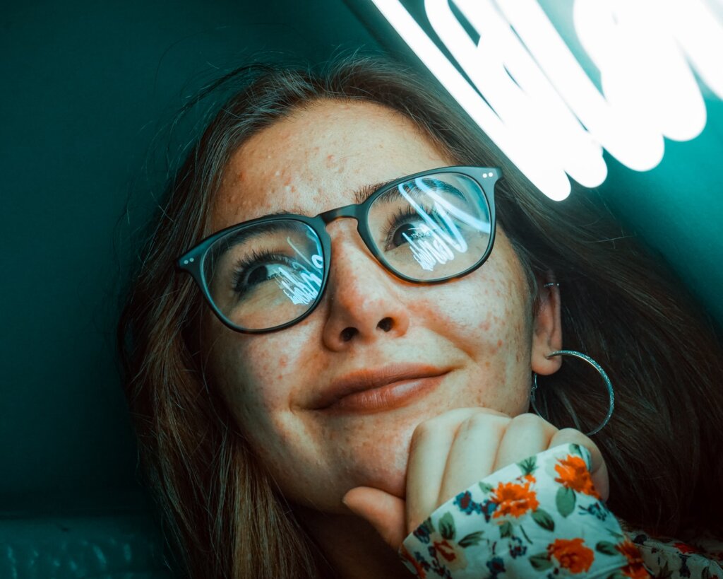 woman in black framed eyeglasses eating food